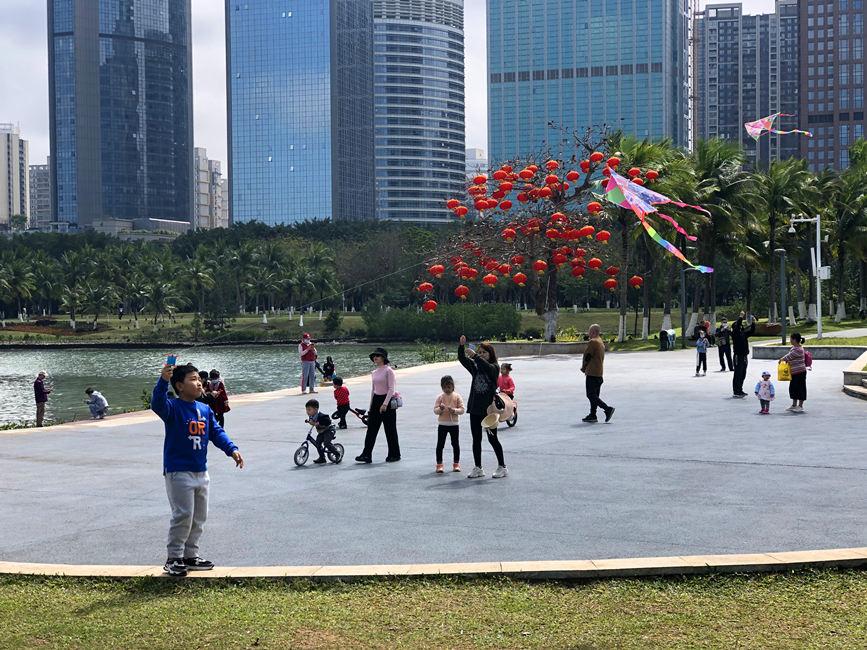 市民在公园嬉戏、游玩，迎着阳光放风筝。人民网 宋彤桐摄