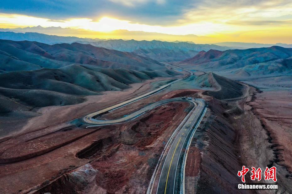 新疆山区柏油路在余晖中像彩带一样倒映出来