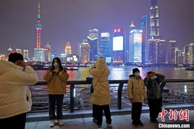 游客欣赏黄浦江两岸夜景并合影。　殷立勤 摄