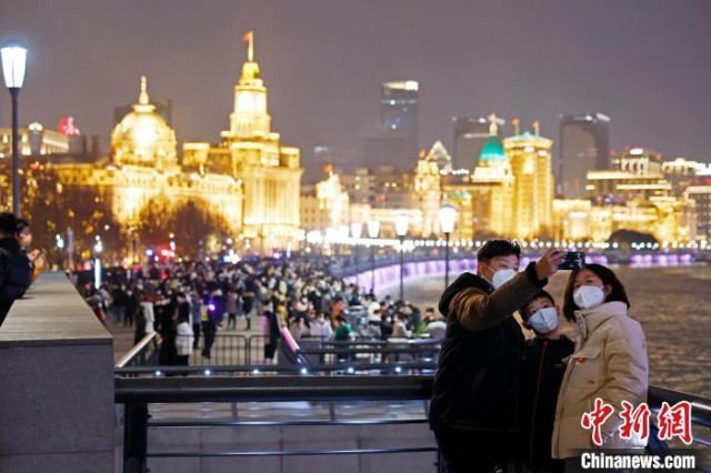 游客欣赏黄浦江两岸夜景并合影。　殷立勤 摄