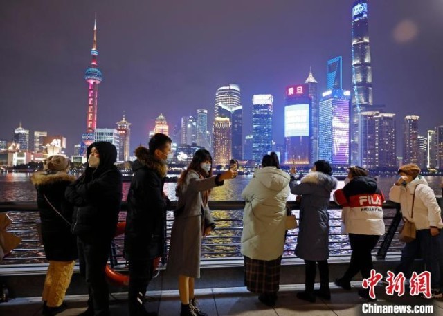 游客欣赏黄浦江两岸夜景并合影。　殷立勤 摄