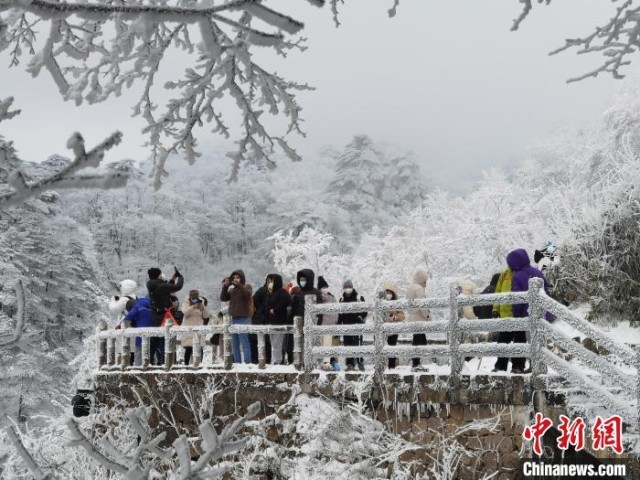 游客在黄山梦笔生花处欣赏黄山雪景 梅建 　摄